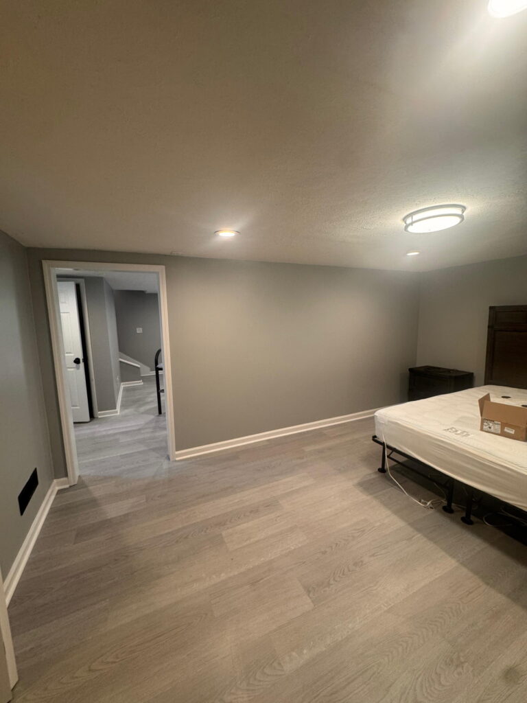 Freshly painted basement bedroom with vinyl plank flooring