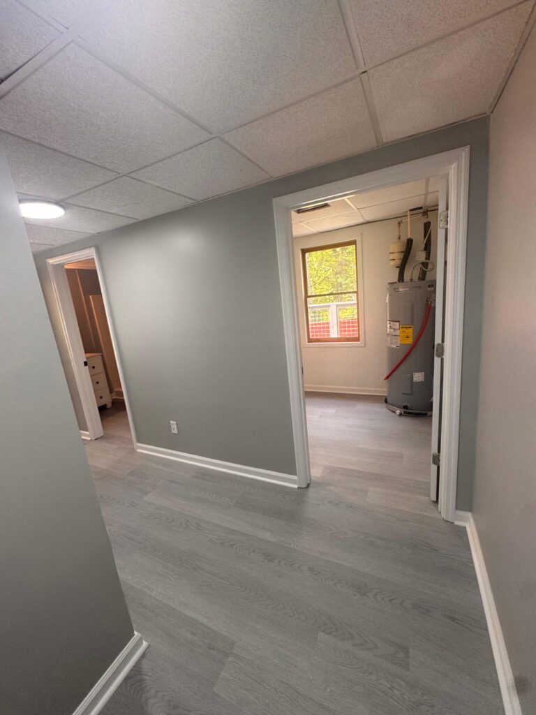 Freshly painted basement hallway with new flooring