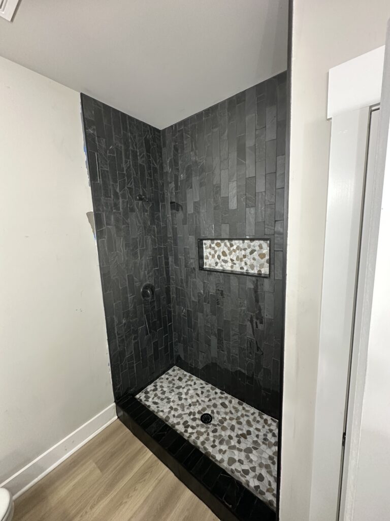 Slate tile shower with pebble floor
