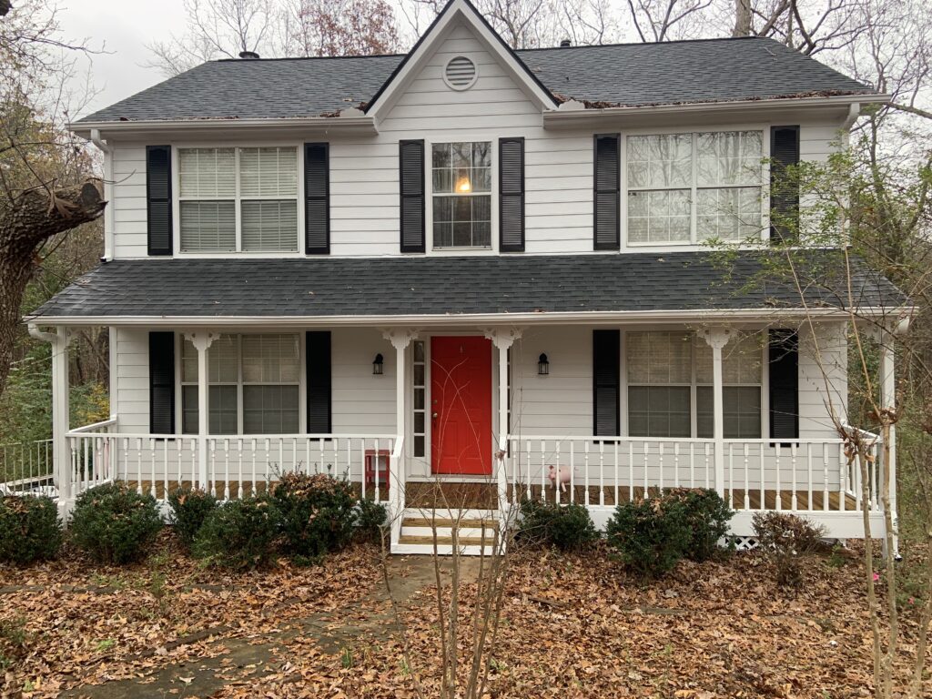 Two-story home with white siding and red door