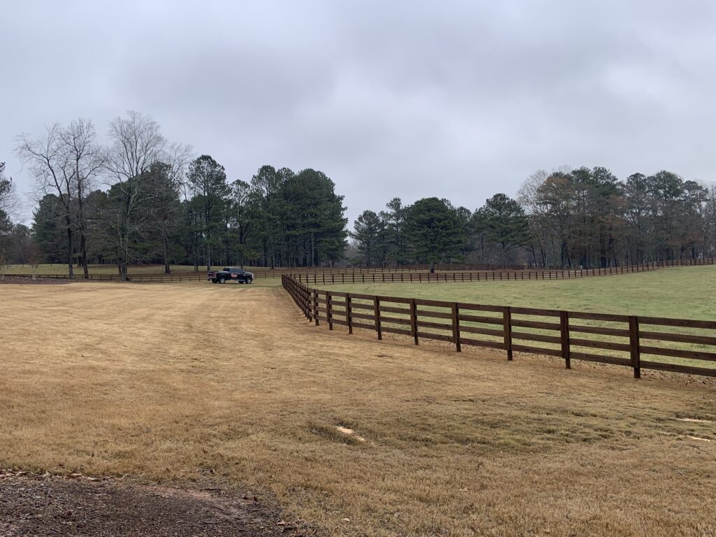 Black four-board pasture fence