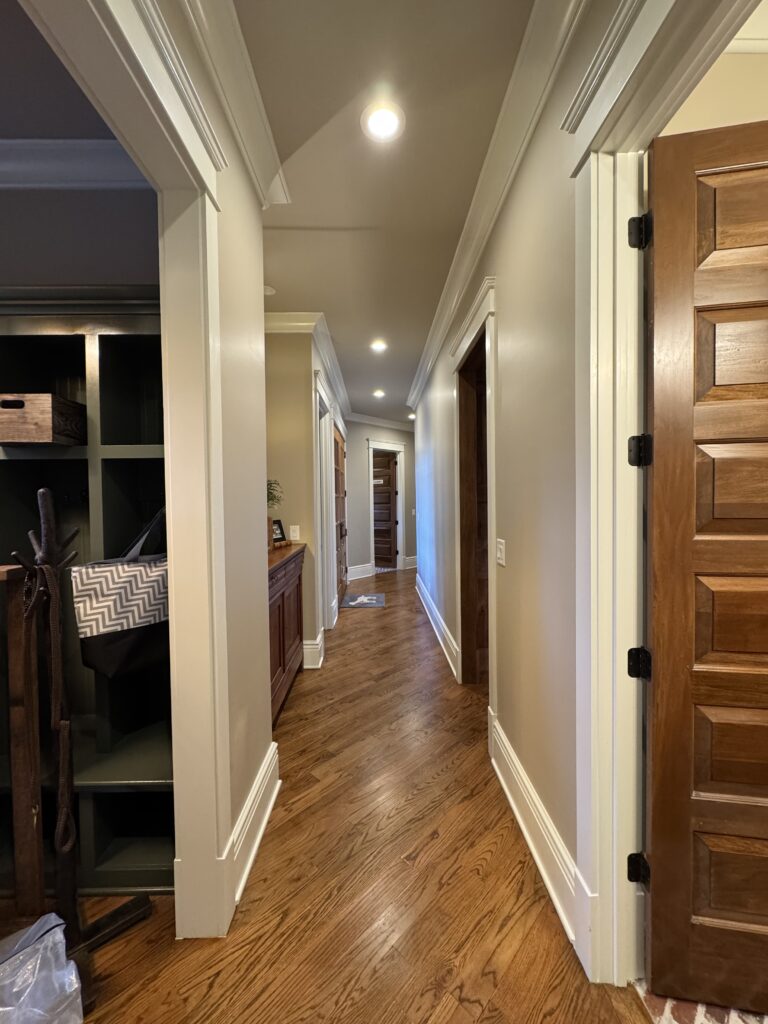 Hallway with hardwood floors and stained doors