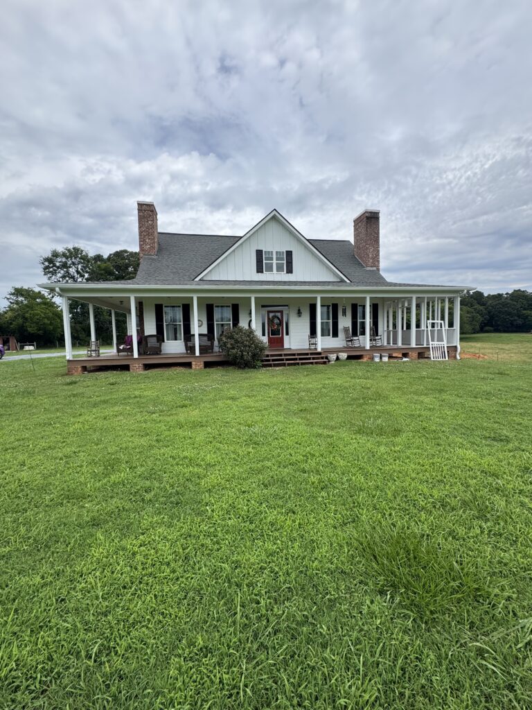 White farmhouse with wraparound porch