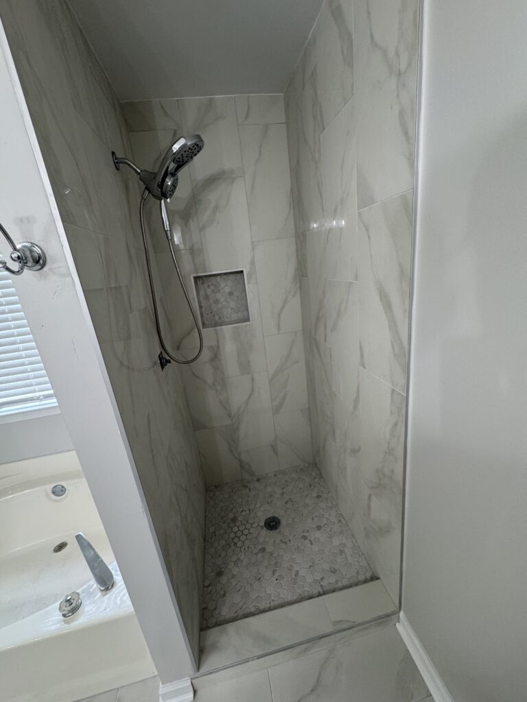 Marble tile shower with glass enclosure