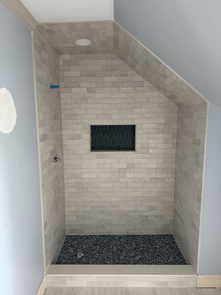 Subway tile shower with black niche